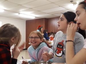 Une jeune fille souriant à pleine dents lors du party de noël des Chouettes de 2019