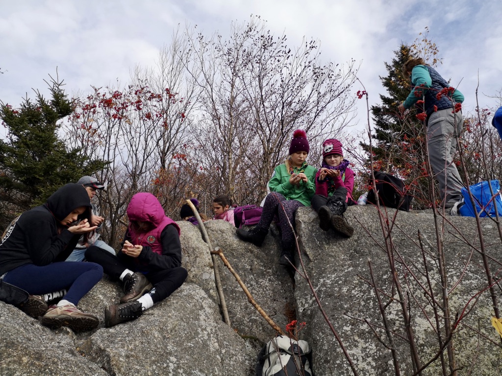 4 jeunes filles de l'unité des Chouettes se reposant au sommet du Mont Chagnon, lors d'une randonnée en automne 2019