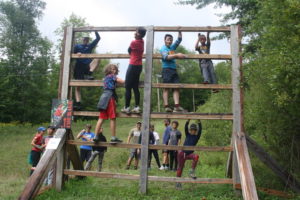 Plusieurs garçons Louveteaux, âgés de 9 à 11 ans, sur une construction en bois, dans un parcours d'hébertisme